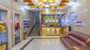 A reception area with a reception desk, a staircase, and a seating area. - Jiahua Business Hotel (Guangzhou North Railway Station Huacheng Road Subway Station) (Guangzhou)