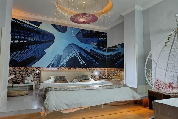 A modern bedroom with a large bed, a hanging chair, and a cityscape mural on the wall. - Jiahua Business Hotel (Guangzhou North Railway Station Huacheng Road Subway Station) (Guangzhou)