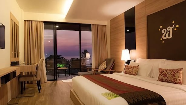 A hotel room with a large bed, a desk, a chair, a TV, and a view of the outside. - Jiahua Business Hotel (Guangzhou North Railway Station Huacheng Road Subway Station) (Guangzhou)