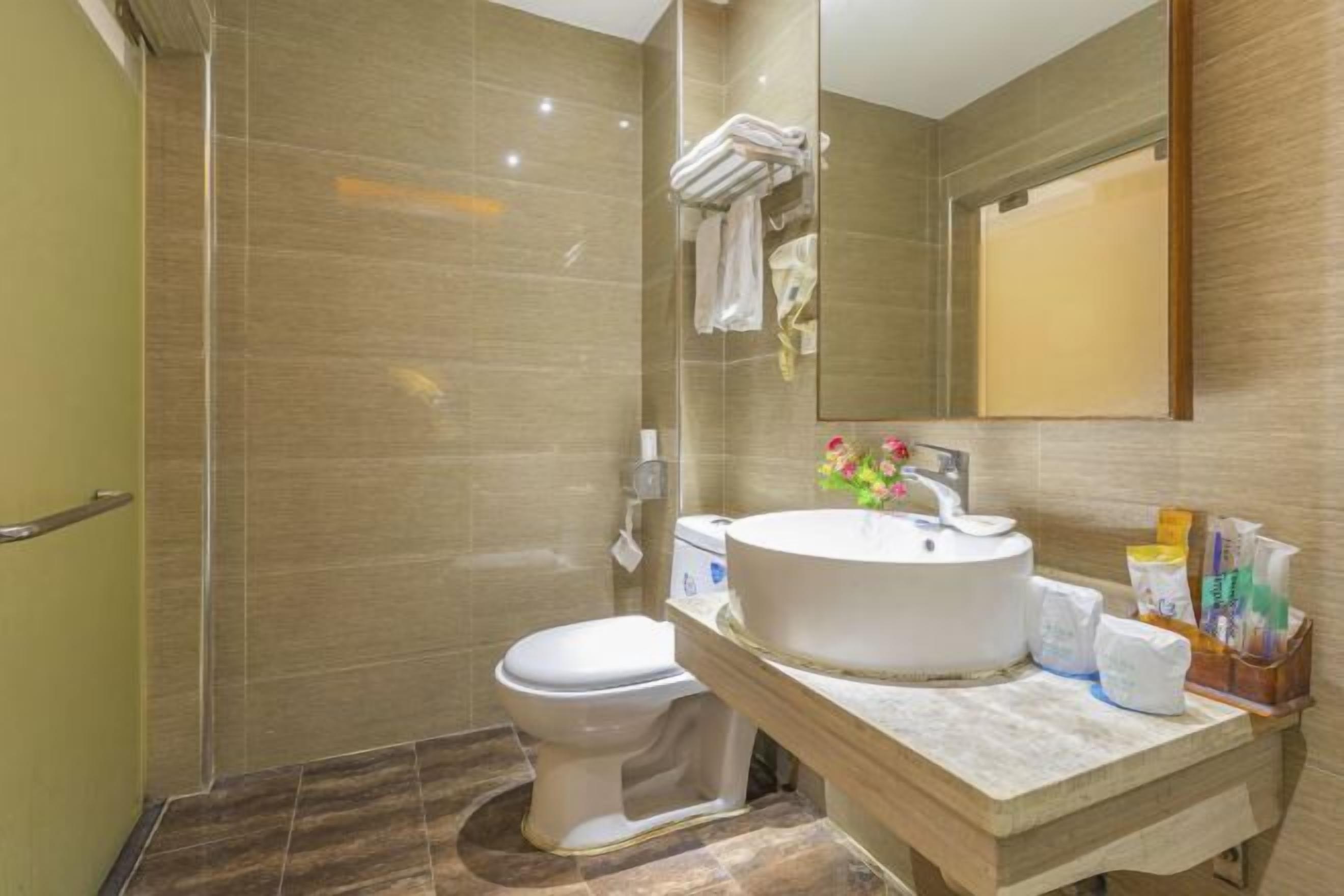 Un baño moderno con inodoro, lavamanos y zona de ducha.