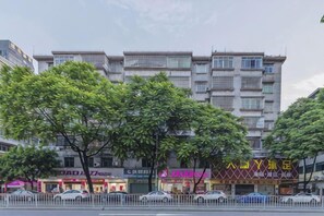 Un edificio a più piani con attività commerciali al piano terra, tra cui un ristorante e un negozio con un cartello ben visibile.