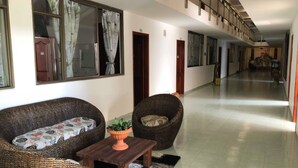A hallway with wicker furniture, a small table, and a potted plant. - Hotel Yurupary (Leticia)
