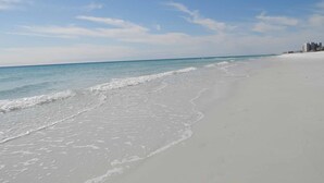 A beach with a clear sky and gentle waves. - Emerald Towers by Southern Vacation Rentals (Destin)