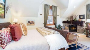 A cozy bedroom with a large bed, a fireplace, and a view of the outdoors. - Ajax Peak Views, Townhome on Sunnyside of Historic Downtown Telluride (Telluride)