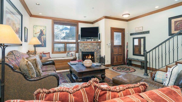 A cozy living room with a fireplace, comfortable seating, and a staircase. - Ajax Peak Views, Townhome on Sunnyside of Historic Downtown Telluride (Telluride)