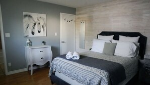 Un dormitorio con cama, mesita de noche y espejo.