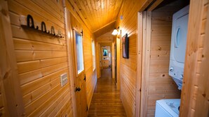 A wooden hallway with a washing machine on the right.