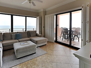Relax in this inviting living area with a sofa, ottoman, and patio access.