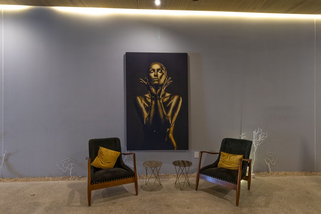 Una habitación con dos sillones, una mesita y un cuadro grande en la pared.