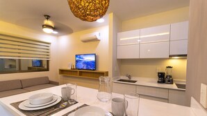 A modern kitchen with white cabinets, a built-in oven, and a coffee maker on the counter. - Gaia 1-BR Suite (Tulum)