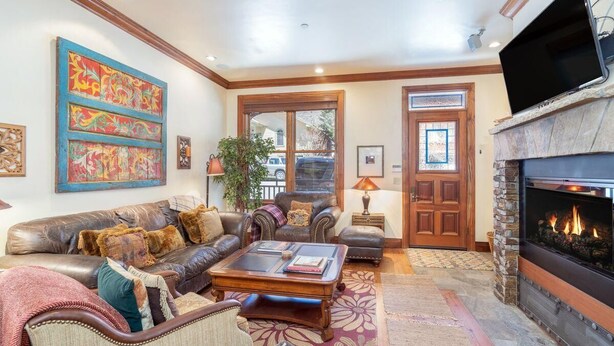 A spacious living room with a leather sofa, a coffee table, and a fireplace. - One of Three Lovely, Sunnyside Town of Telluride Homes-Select 1, 2, or All 3! (Telluride)