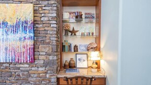 A cozy corner with a wooden desk, a stone wall, and a glass shelf with decorative items. - One of Three Lovely, Sunnyside Town of Telluride Homes-Select 1, 2, or All 3! (Telluride)