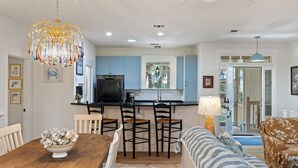 Una cocina moderna con una isla central, taburetes de bar y una mesa de comedor.