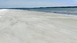 Una playa con una extensa orilla de arena y un mar tranquilo.