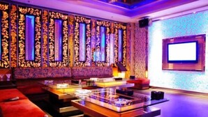A modern hotel lobby with a reception desk, seating area, and a large screen. - Jianglong Hotel (Dongguan Houjie Wanda Plaza) (Dongguan)