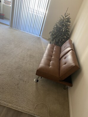 Relax in this inviting living room with a comfortable sofa and large window.