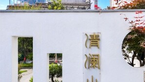 Een gebouw met traditionele architectuur en een bord met Chinese karakters.