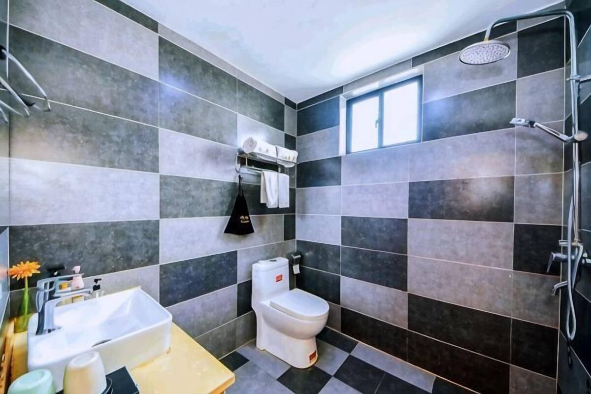 A bathroom with a toilet, sink, and shower.