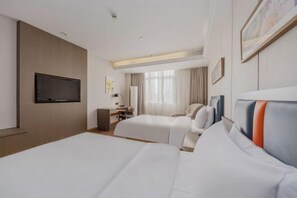 A hotel room with two beds, a desk, a chair, a TV, and a window with curtains.