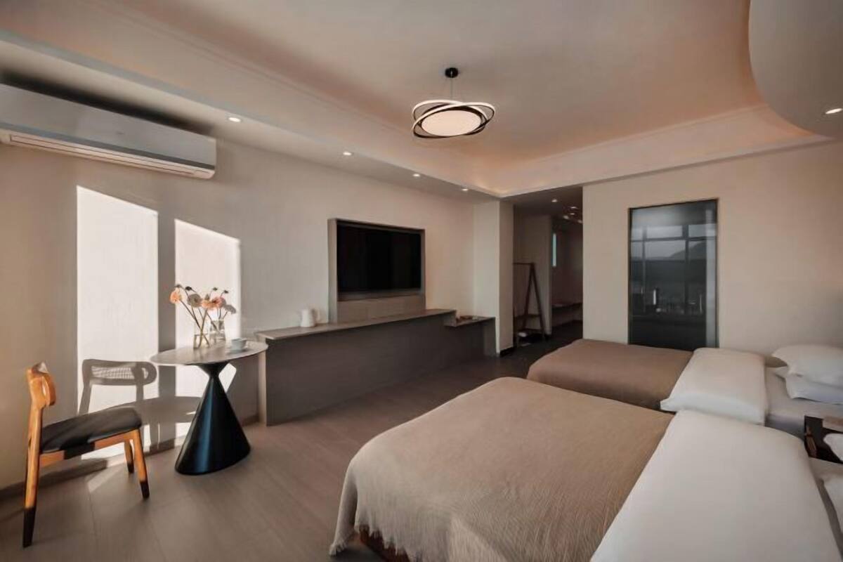 Ein modernes Hotelzimmer mit einem Bett, einem Schreibtisch, einem Stuhl und einem Fernseher.