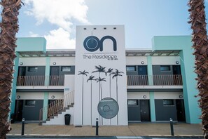 A building with a sign that reads 'on The Residence at the sea' and palm trees on the facade. - ON The Residence (Almonte)
