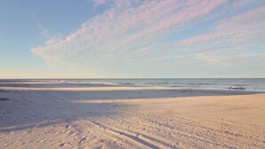 A beach with a wide sandy shore and gentle waves. - Tortuga Shoals (Tierra Verde)