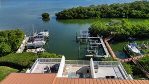 A marina with boats docked, surrounded by lush greenery and a clear view of the water. - Tortuga Shoals (Tierra Verde)