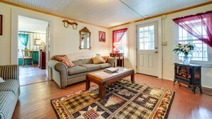 A cozy living room with a checkered sofa, a wooden coffee table, and a patterned rug. - Pet-Friendly Smoky Mountain Getaway w/ Fire Pit! (Clyde)