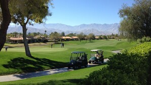 A golf course with a clear view of the mountains in the background.