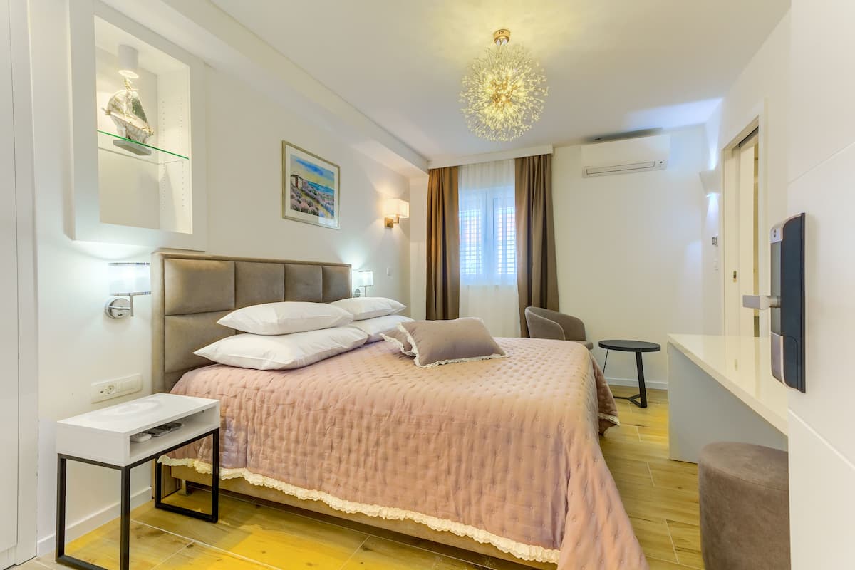 A modern bedroom with a bed, bedside table, and a small desk.