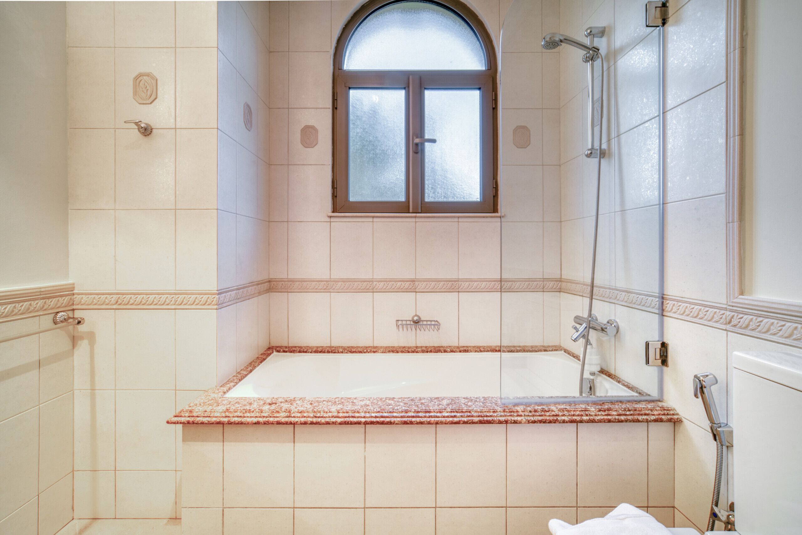 Une salle de bain avec une baignoire, une douche et une fenêtre.
