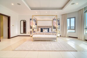Ein geräumiges Schlafzimmer mit einem großen Bett, einem Baldachin und Blick auf die Stadt.