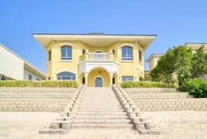 Un bâtiment à deux étages doté d’un balcon, d’une porte d’entrée et d’un escalier menant à l’entrée.