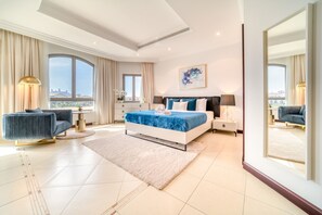 Une chambre moderne avec un grand lit, un coin salon avec un canapé et une vue sur la ville.