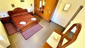 A bedroom with a bed, a wardrobe, a mirror, and a bedside table. - HOUSE SEA MOUNTAIN (Bonarcado)