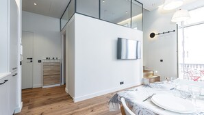 A modern interior with a dining area, kitchen, and a glass-enclosed upper level. - Le Victor Hugo, air conditioning, elevator, balcony (Nice)