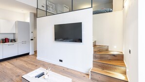 A modern kitchen with white cabinets, a built-in stove, and a dining area with a table and chairs. - Le Victor Hugo, air conditioning, elevator, balcony (Nice)