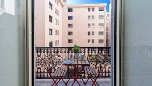 A balcony with a table, chairs, and a potted plant. - Le Victor Hugo, air conditioning, elevator, balcony (Nice)