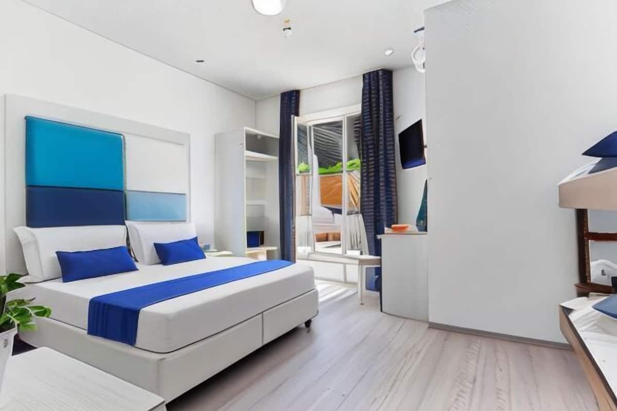 Una habitación de hotel moderna con una cama grande, un escritorio y un televisor.