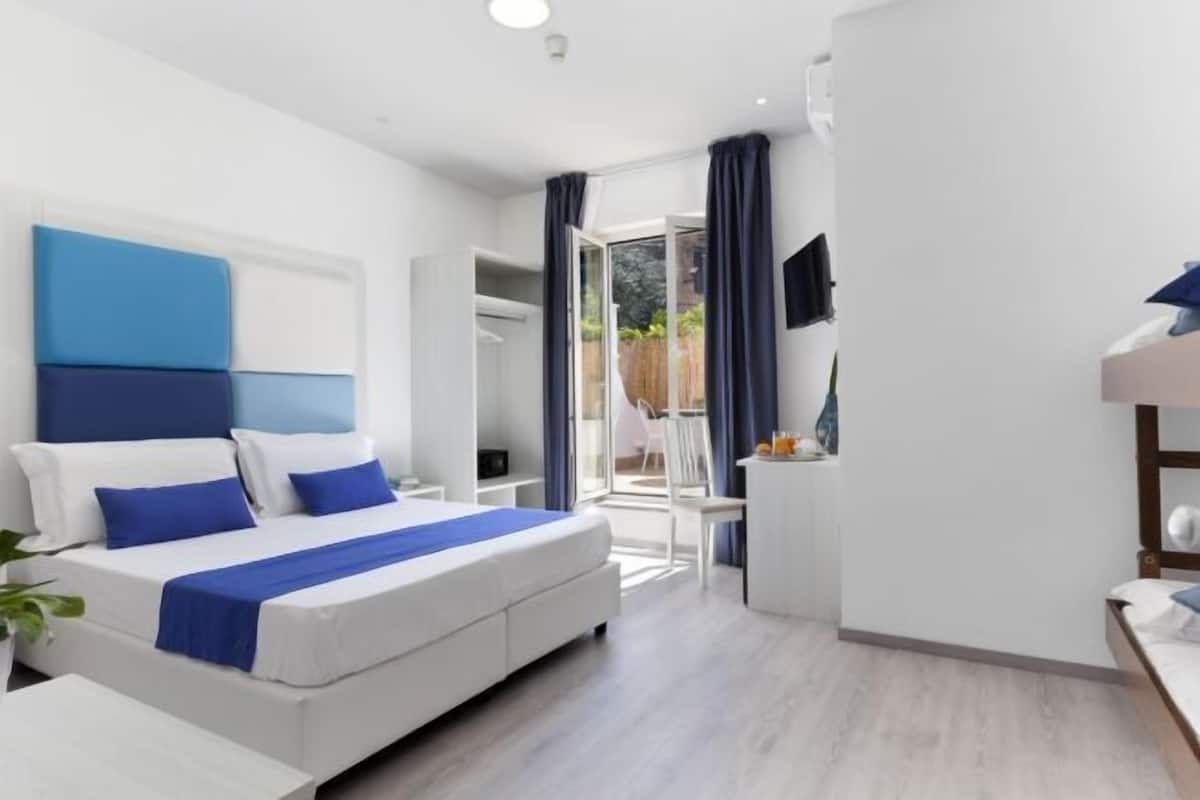 Habitación de hotel moderna con cama, escritorio y vistas al exterior.