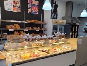 A bakery display case with various baked goods and a sign above it.