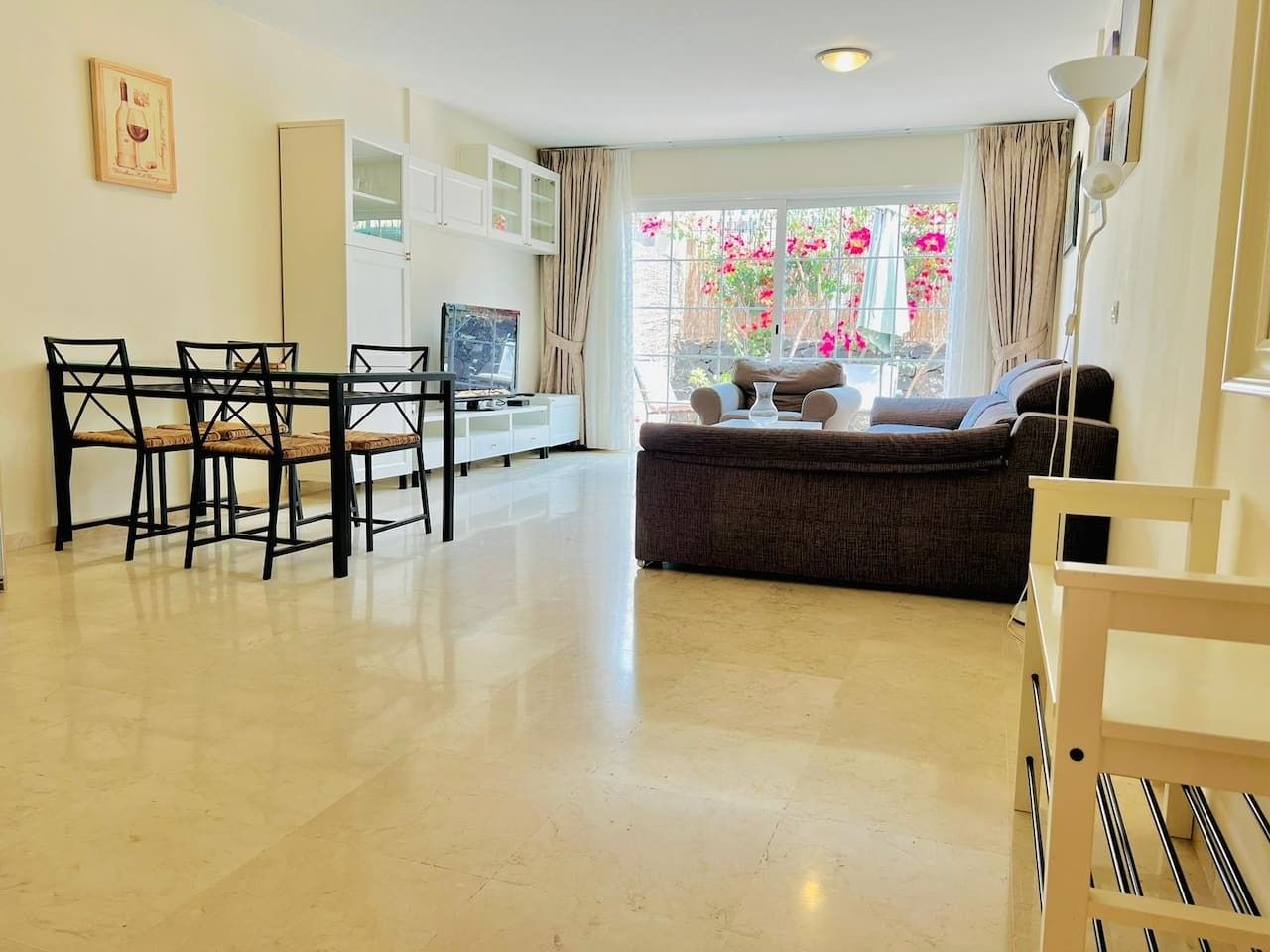 A living room with a dining area, a sofa, and a TV.