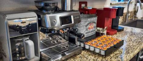 A kitchen with a coffee machine, a kettle, and a tray of cookies.