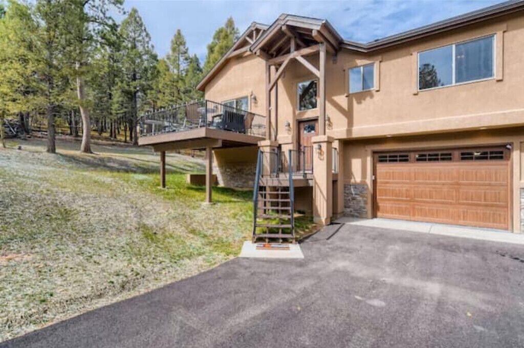 A two-story house with a covered porch, a garage, and a staircase leading to the upper level.