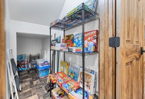 Games and cleaning supplies are stored on the shelves in this tidy space.