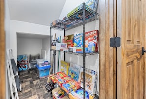 Games and cleaning supplies are stored on the shelves in this tidy space.