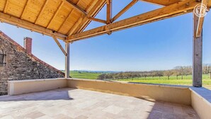 A covered outdoor terrace with stone walls and a view of a green landscape. - la Corbière - Martigny-le-comte (MARTIGNY-LE-COMTE)