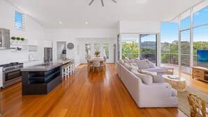 Un espace de vie moderne à aire ouverte comprenant une cuisine, un coin repas et un balcon avec vue.