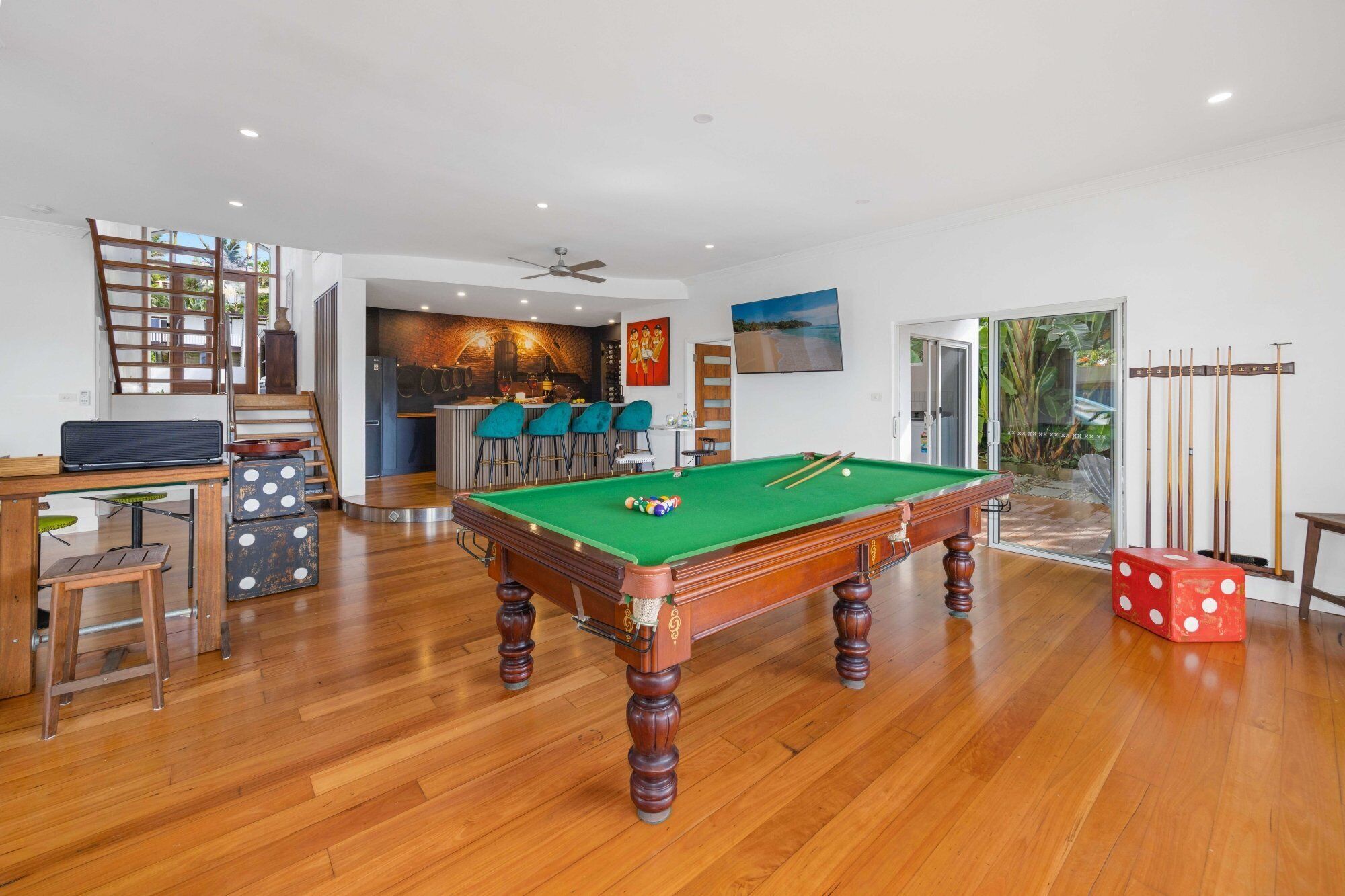 Um quarto amplo com mesa de bilhar, área de bar e vista para o exterior.