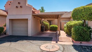 A residential building with a garage, a covered walkway, and well-maintained landscaping.